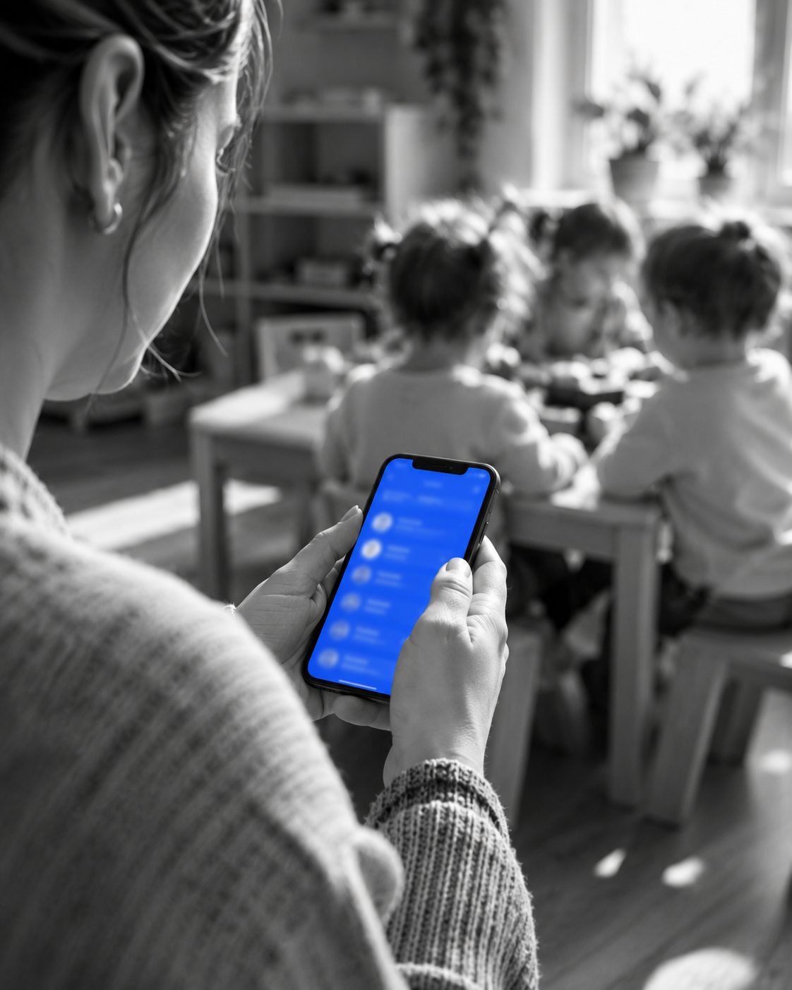 Kinderbegeleider gebruikt de tjouly-app terwijl de kinderen spelen