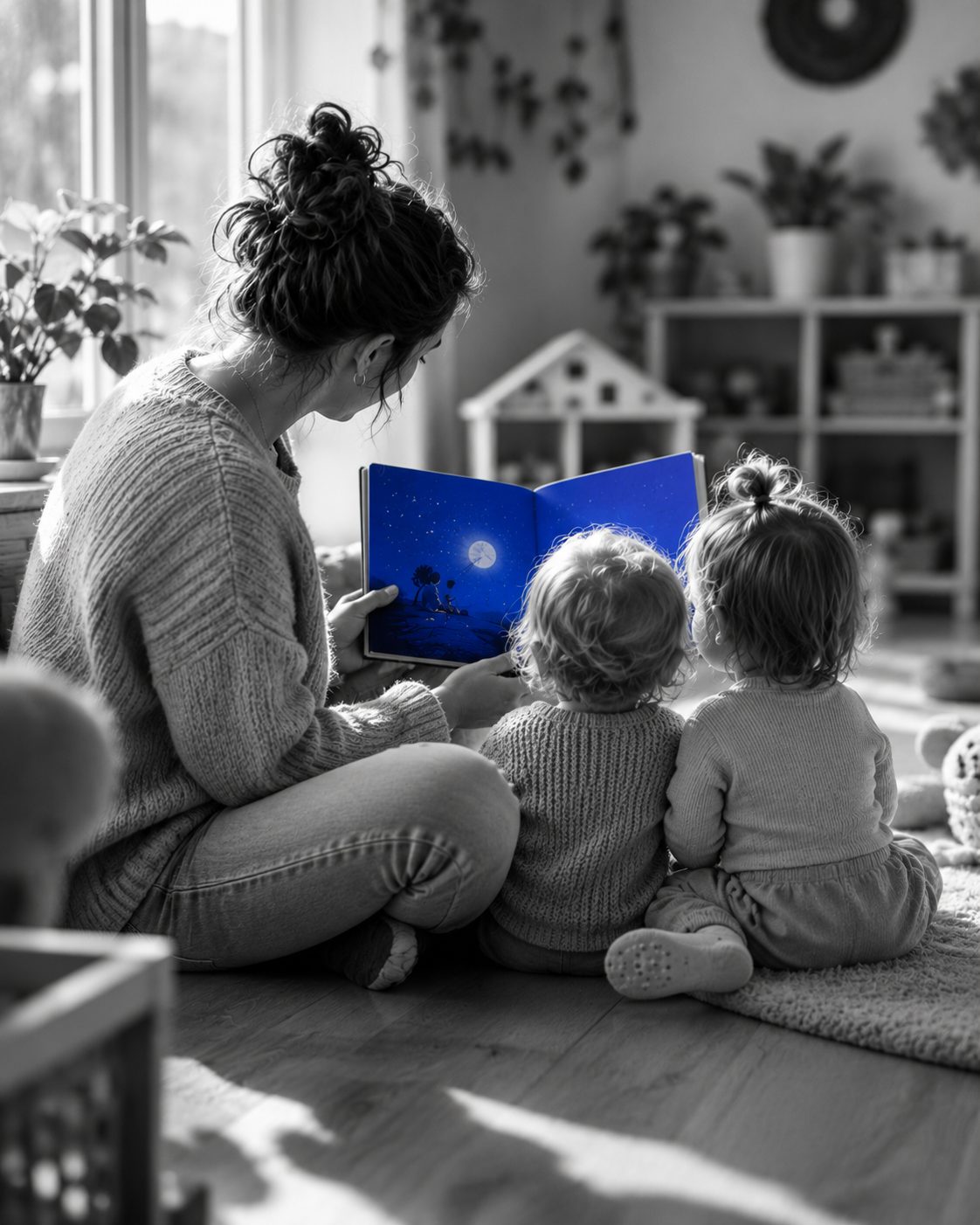 Kinderbegeleider leest rustig voor aan twee peuters